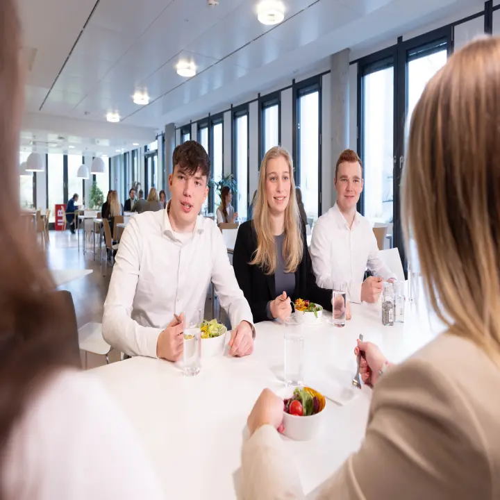 Menschen sitzen auf einer Treppe im ILB-Gebäude